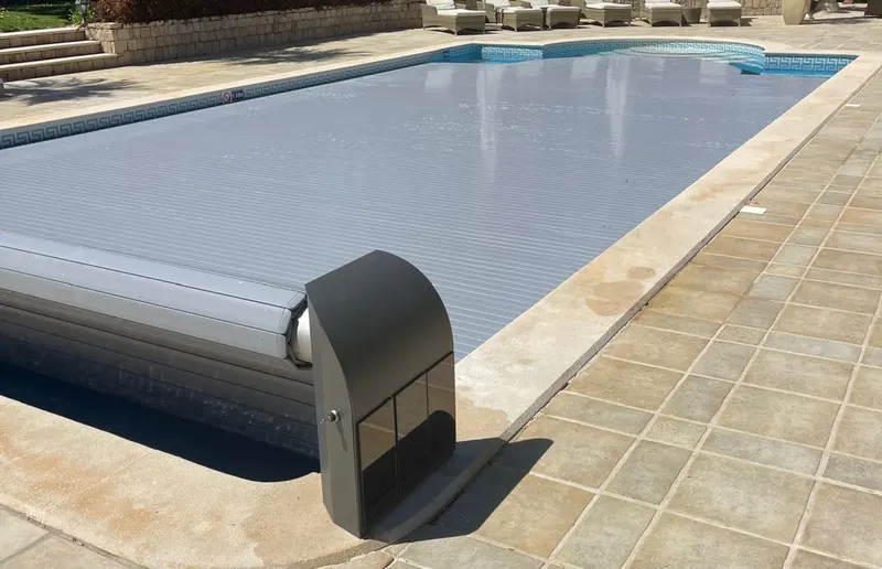 Piscina totalmente fechada pela cobertura automática de lâminas cinzentas